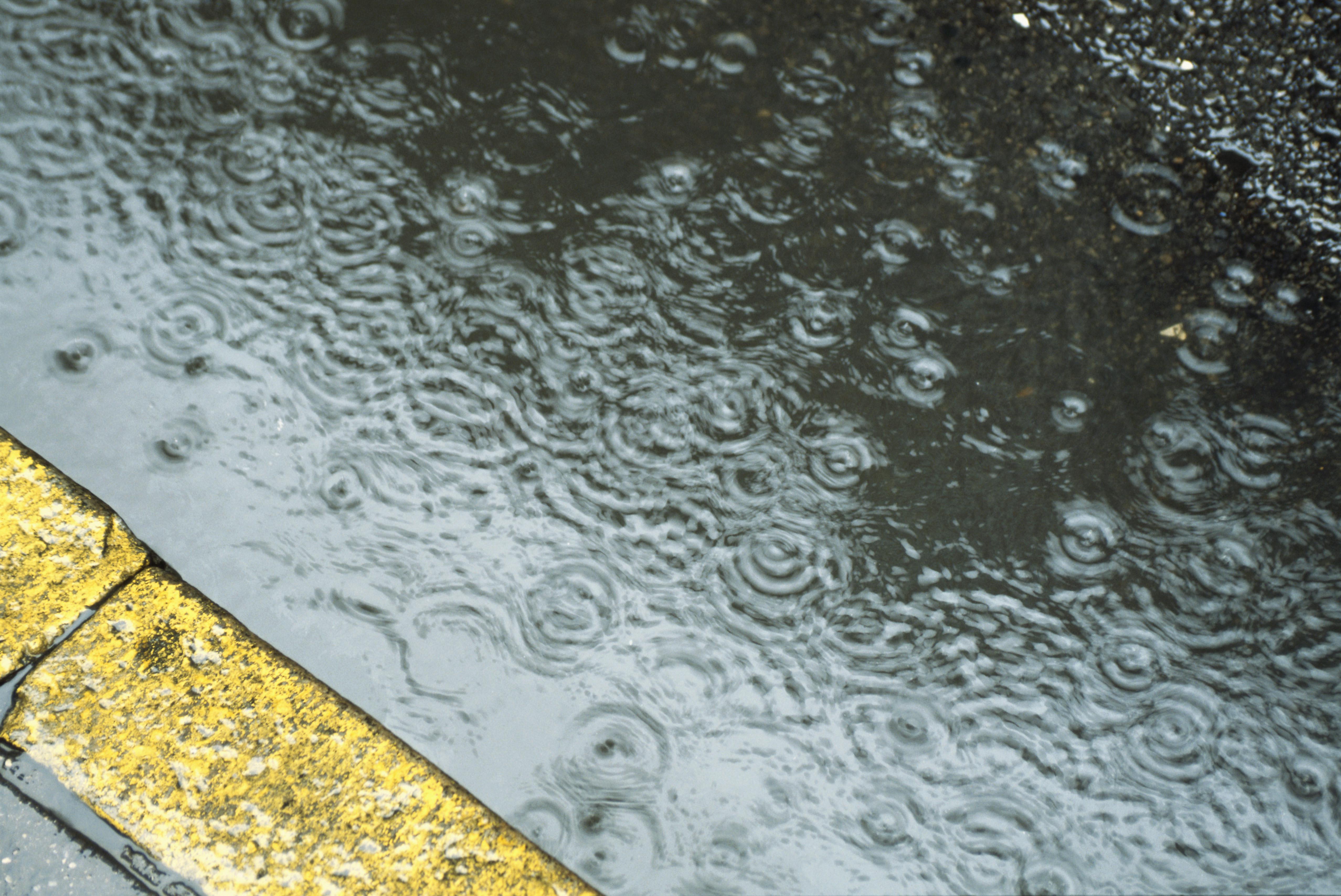 Rain drops falling on road, elevated view