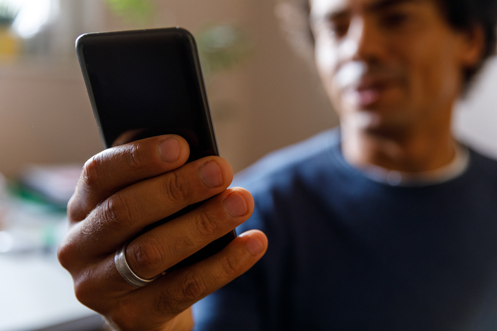 Man using smart phone, responding to text messages