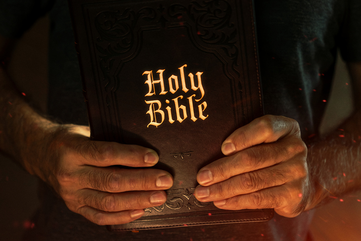 Man Holding Holy Bible in Hands