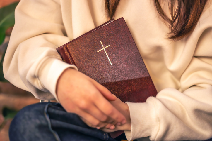 Woman holds a Bible in her hands. Religion concept. Bible close up.