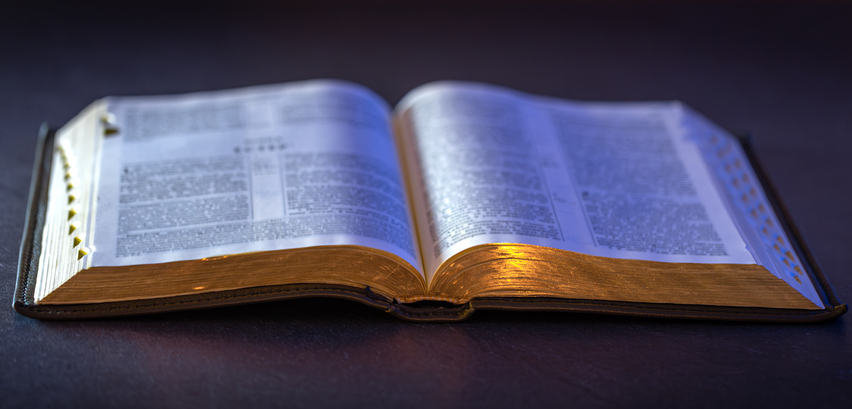 Open Holy Bible on the table. Religion concept. Bible on black background.